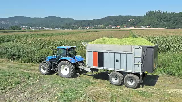 空中拖拉机驾驶着装满玉米秸秆的集装箱视频下载