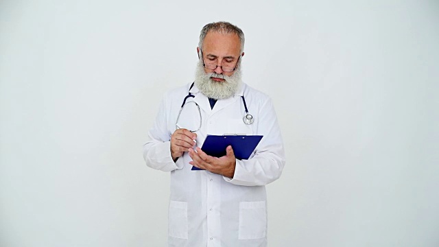 成年资深医生在灰色背景的剪贴板上写字视频素材