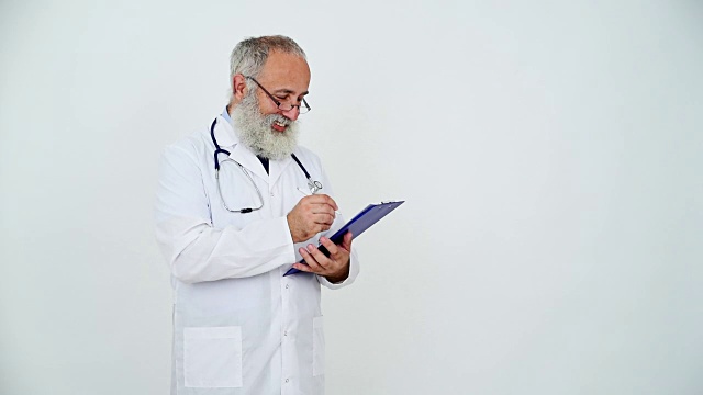 一位成年医生在灰色背景的写字板上写字。视频素材
