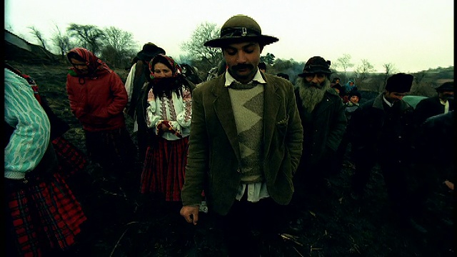 在罗马尼亚特兰西瓦尼亚的西比乌泥泞的田野里，一群穿着土著服装的人抬起身子走向摄像机视频素材