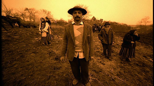 在特兰西瓦尼亚的斯比乌，SEPIA摄影向站在田野里的戴帽子的人/其他穿着土著服装的人射击视频素材
