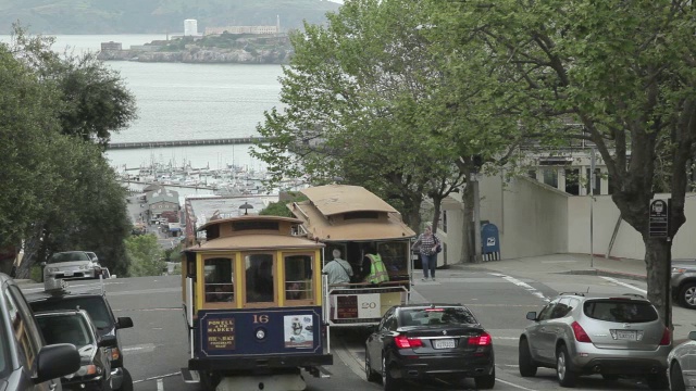 中景:旧金山的电车驶过，背景是恶魔岛视频素材