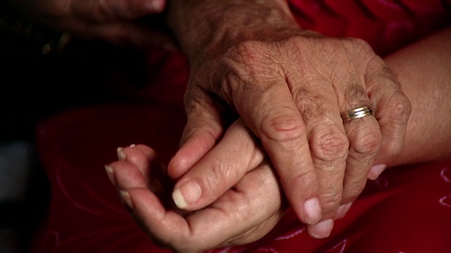 靠近老男人的手，抚摸+握住老女人的手视频素材