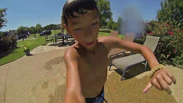 一个年轻的西班牙男孩在夏天跳进后院的游泳池视频素材