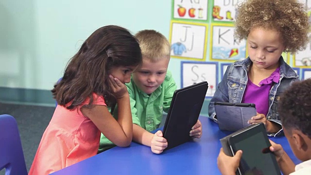 6个多民族儿童在学校使用电子平板电脑视频素材