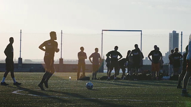 一群年轻人在日落时踢足球——2016年夏天——4k视频素材