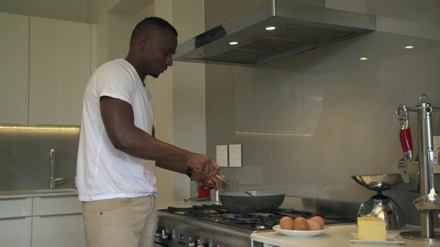 图为南非西开普省开普敦的一名非洲男子在厨房做饭视频下载