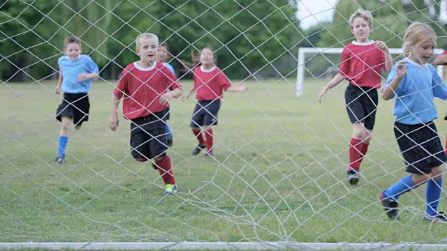 小学生在户外踢足球视频素材