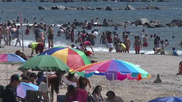 拥挤的科尼岛海滩，人们在海里游泳视频素材