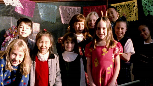 高对比度的MS肖像组的孩子微笑/一些在背景给“兔子耳朵”女孩在前景视频素材