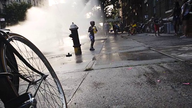 2016年夏天，孩子们在纽约布鲁克林街道的一个消防栓里保持凉爽。视频下载