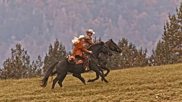 SLO MO TS牛仔和女牛仔骑着他们疾驰的马视频下载