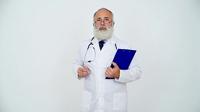 一位成年医生在灰色背景的写字板上写字。视频素材