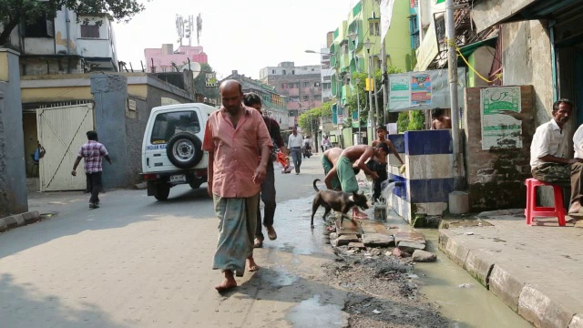 加尔各答(欢乐之城)，一名男子在街上洗衣服视频下载