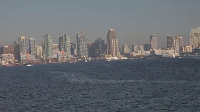 从右到左，从港口到摩天大楼和高层写字楼或公寓在城市天际线。港口或海湾里的帆船。视频素材