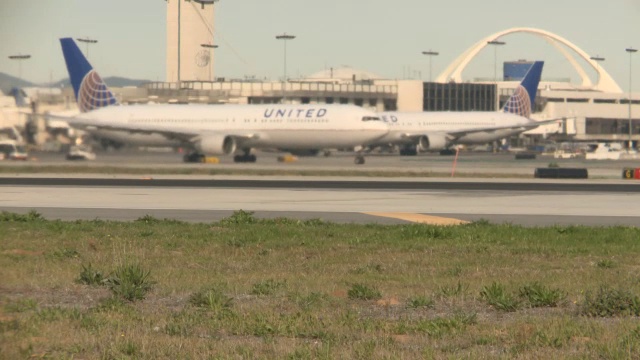 右转右转的民航客机，飞机在洛杉矶国际机场的跑道上。视频素材