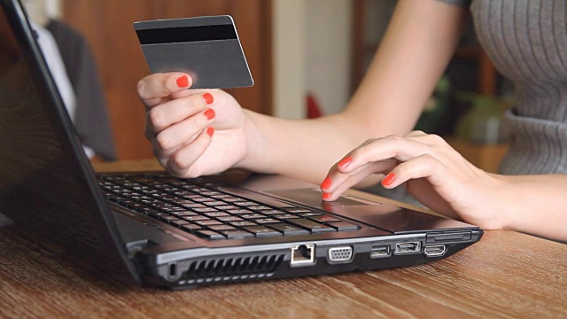 持有信用卡并使用笔记本电脑进行网上购物的女子视频素材