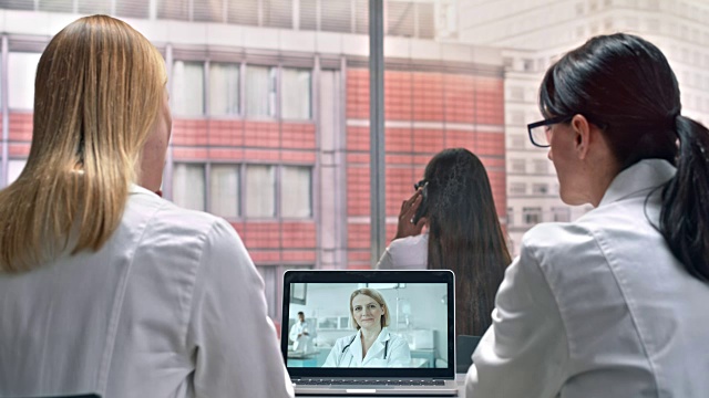 两位女医生正在和她们的实验室同事视频通话视频素材