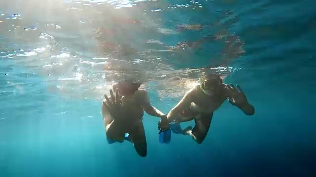 POV夫妇在阳光下牵手潜水视频素材