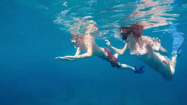 一个年轻人和他的女朋友一起潜水视频素材