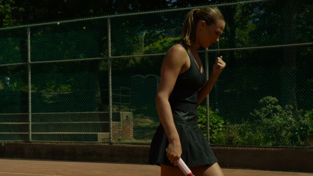红土网球场上女子反手回传的慢动作高球视频素材