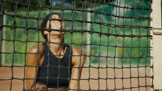 慢镜头上方的平底锅女子坐在网球场的阴影上庆祝视频素材