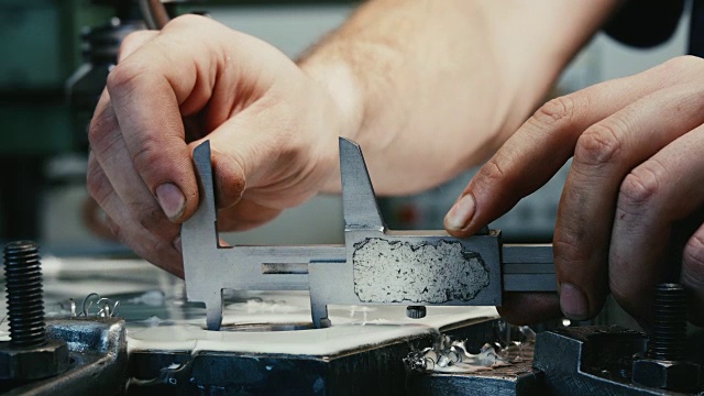 工厂里的工人用游标卡尺测量钢孔。视频下载
