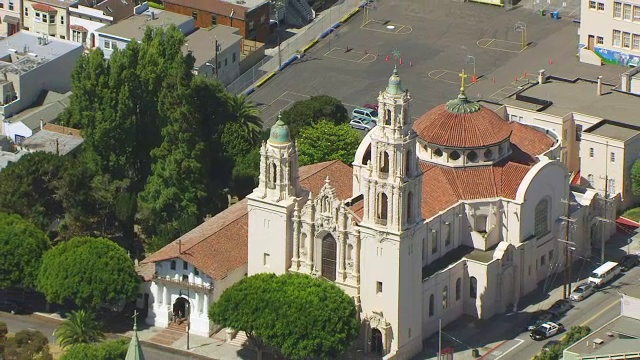 WS ZO AERIAL POV鸟瞰Dolores教堂与城市景观，汽车在道路上移动/旧金山，加利福尼亚，美国视频下载