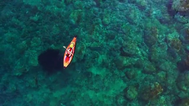 用无人机拍摄的航拍画面，两个女孩在地中海科斯塔布拉瓦的一个田园诗般的地方，清澈清澈的海水中练习划艇。4 k UHD。视频下载