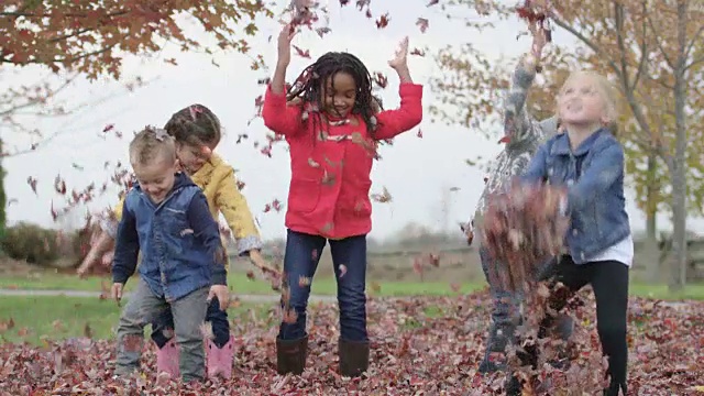 小学生把秋叶抛向空中视频素材
