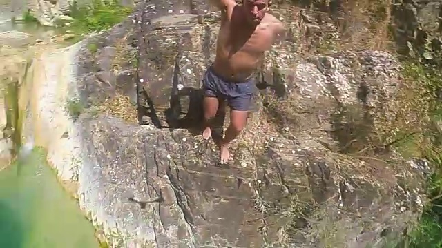 一个人在加泰罗尼亚比利牛斯山脉一个隐蔽的田园式的地方，在美丽的绿色水域中跳跃的慢镜头拍摄了360度的自拍照，以原始的视角展示了所有的环境。视频下载