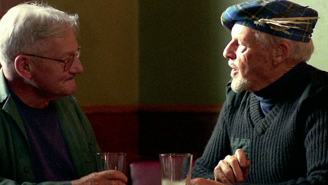 新斯科舍塔姆-奥-香特(tamo '-shanter)的酒吧里，两名中年男子坐在桌子上喝着啤酒聊天视频素材