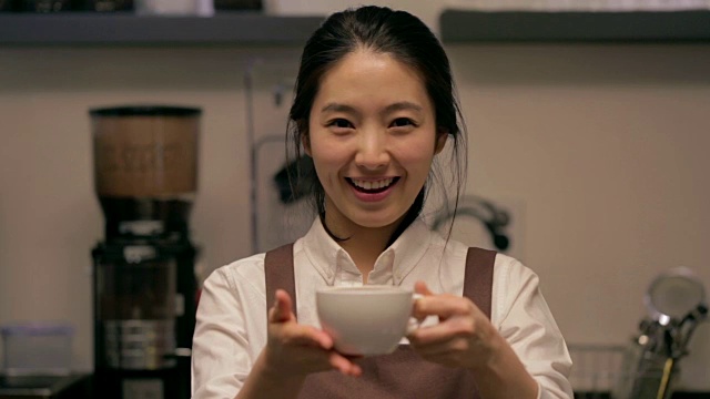 女咖啡师手里拿着咖啡杯在咖啡馆视频素材