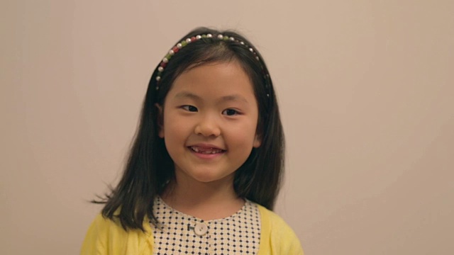 小东亚女孩戴着发带微笑视频素材
