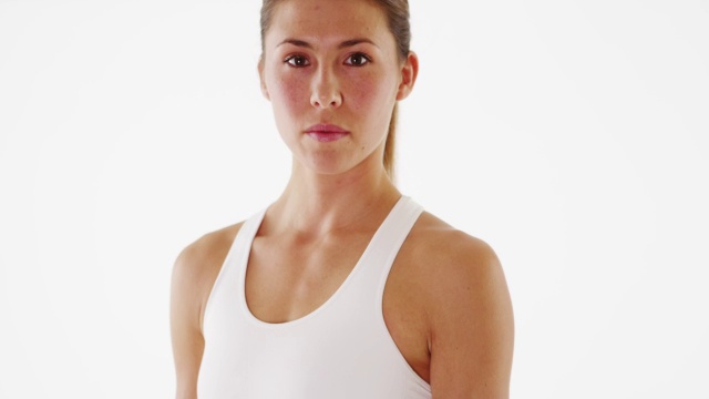 迷人的健身女教练站在白色的背景视频下载