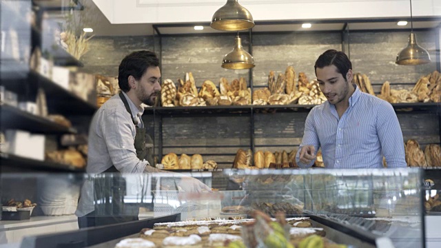 顾客在看面包店的选择和售货员的服务视频素材