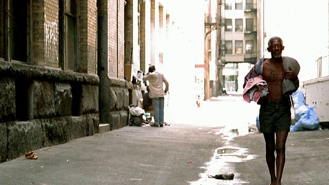 高对比成熟的黑人男子在敞开的衬衫(无家可归者)走在小巷的相机/洛杉矶视频素材