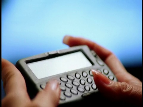 非常近的女性手指打字的无线itnernet设备(PDA)与蓝色背景视频素材