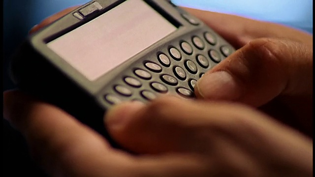男性手指在无线互联网设备(PDA)上打字的特写视频素材