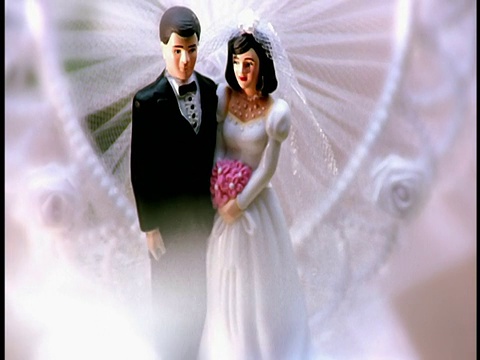 靠近倾斜的婚礼蛋糕与微型塑料新娘和新郎视频素材