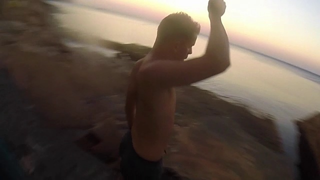 一名男子在地中海科斯塔布拉瓦海岸线的一个天然水池中日出时的慢镜头拍摄了360度的自拍照，以原始的视角展示了所有的环境。视频素材