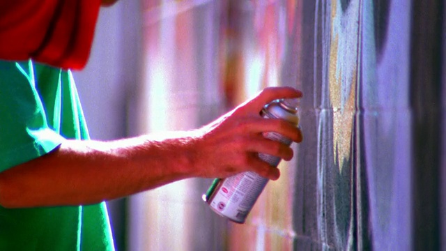 两个年轻人的侧面手臂在墙上喷漆/洛杉矶视频下载