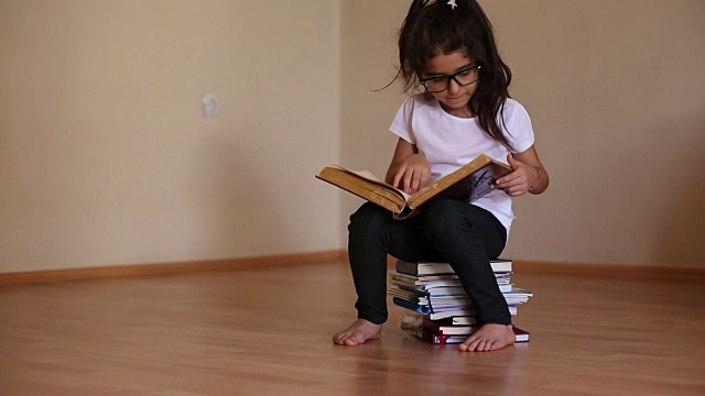小女孩戴着眼镜看书视频素材