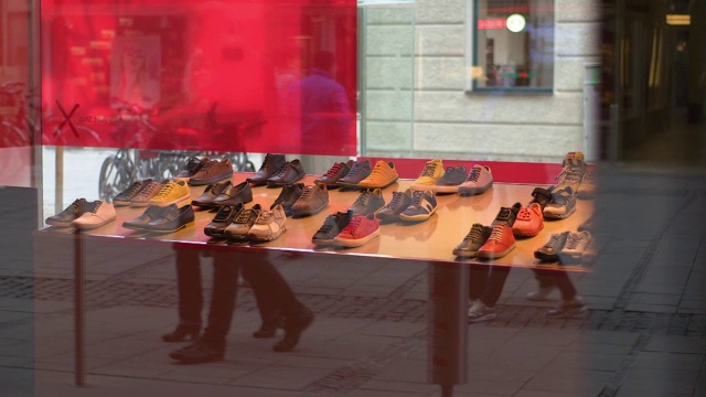 人们映在一家鞋店的橱窗里，拍下了照片视频下载