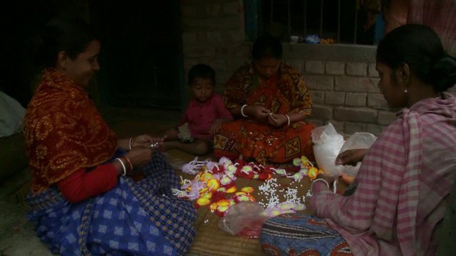 三个印度妇女在做花卉项链。视频素材