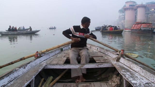在印度的恒河上，一个男人一边说话一边划船。视频下载