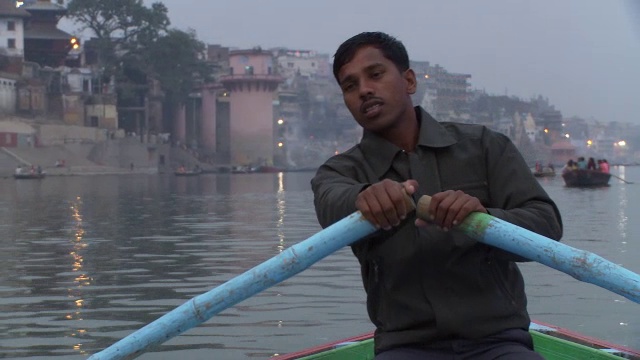 一名男子在印度雾蒙蒙的恒河上划船的特写。视频下载