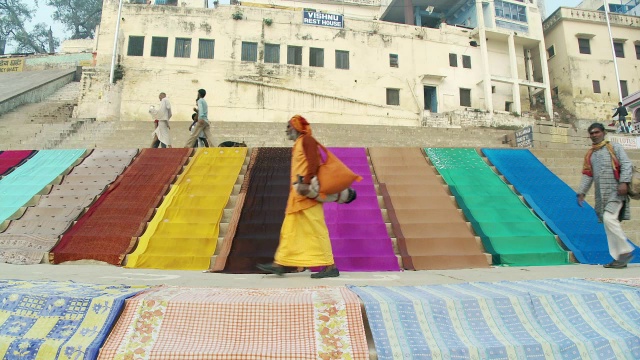 在台阶上走过彩色织物的人视频素材