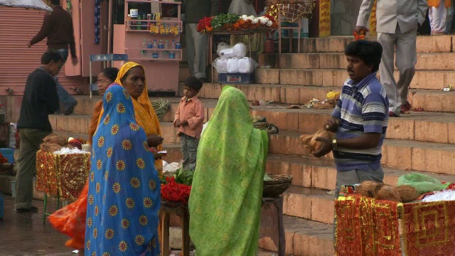男人打开椰子，三个女人等在台阶上视频素材
