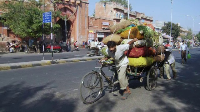人们推着堆满了蔬菜的货物自行车视频素材